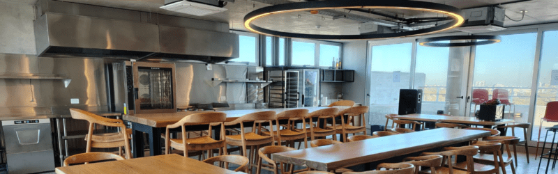 Área de comedor corporativo con cocina industrial y diseño moderno en oficinas Finnegans.