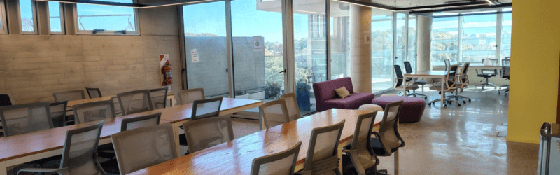 Espacio de trabajo de planta libre con muro de hormigón visto y terminación de tablas.