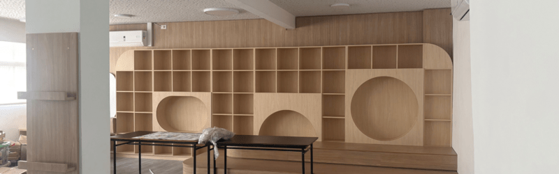 Estantería de madera a medida con nichos circulares y cuadrados en aula de la Escuela Buber.