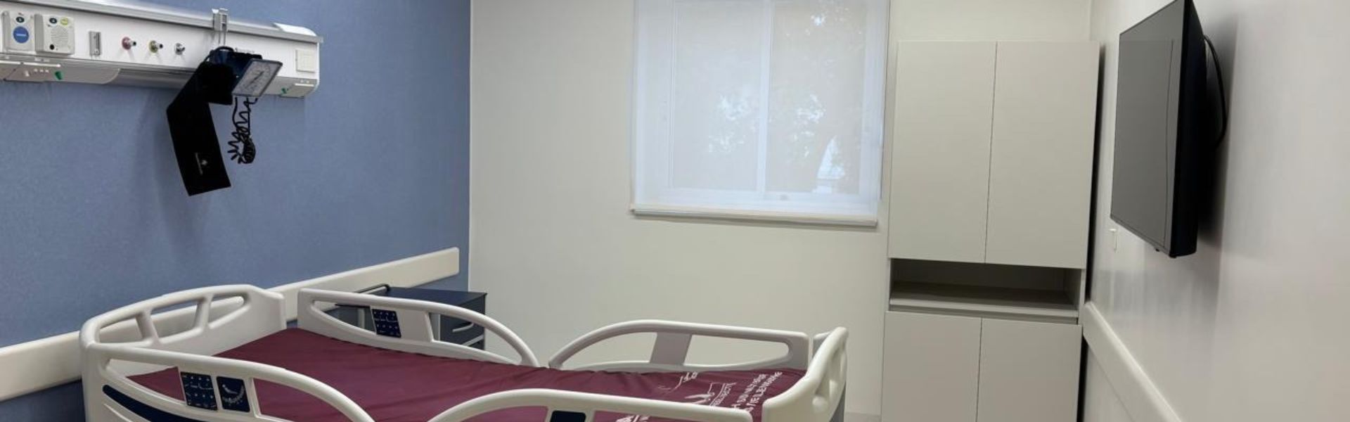 abitación de maternidad renovada con panel de gases medicinales y mobiliario hospitalario.