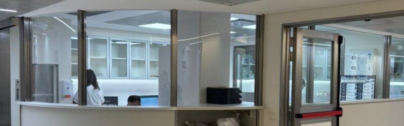 Estación de enfermería y control con cerramientos vidriados y superficies de trabajo ergonómicas en Sanatorio Mater Dei.