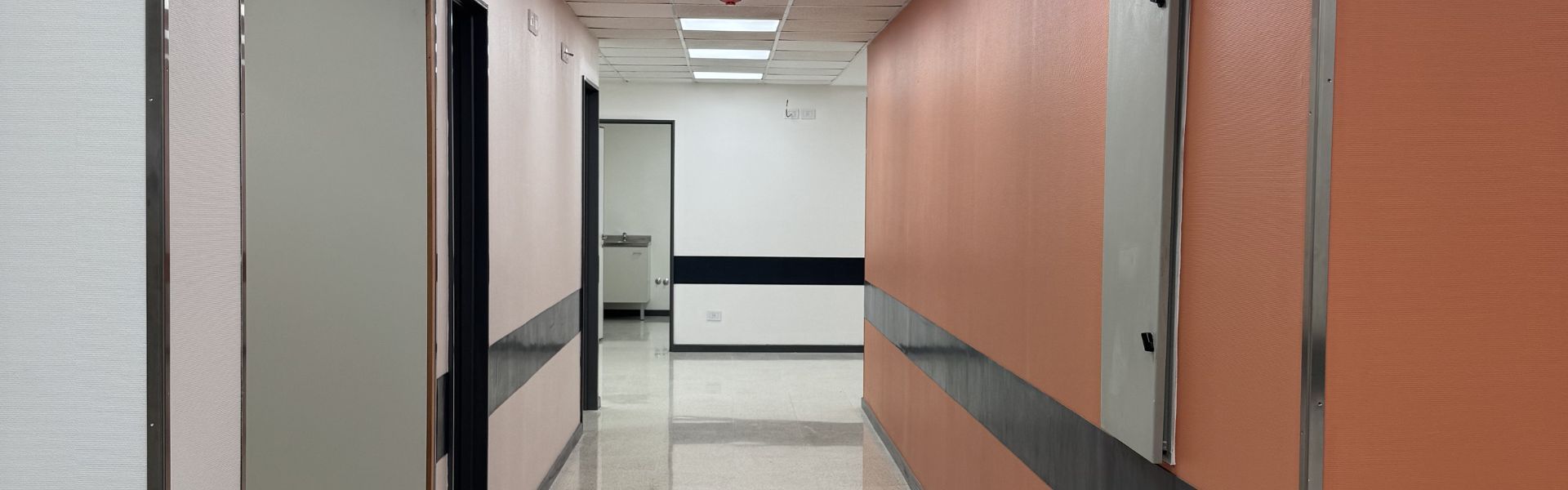 Pasillo de consultorios médicos remodelado en Corporación Médica San Martín por Thesing, enfocado en optimización espacial